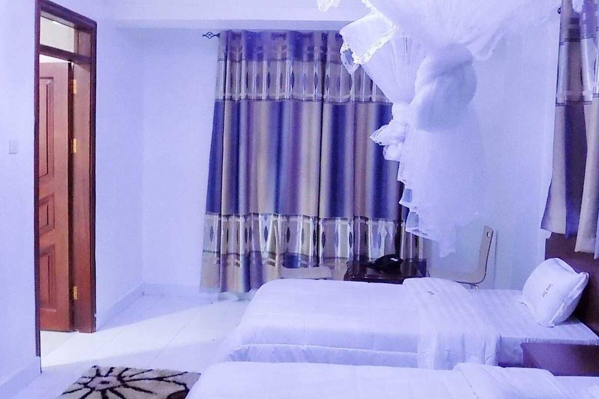 A room with a bed, a television, and a door.