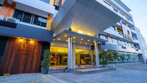 Un hotel moderno con una entrada destacada, varios pisos y una fachada bien iluminada.