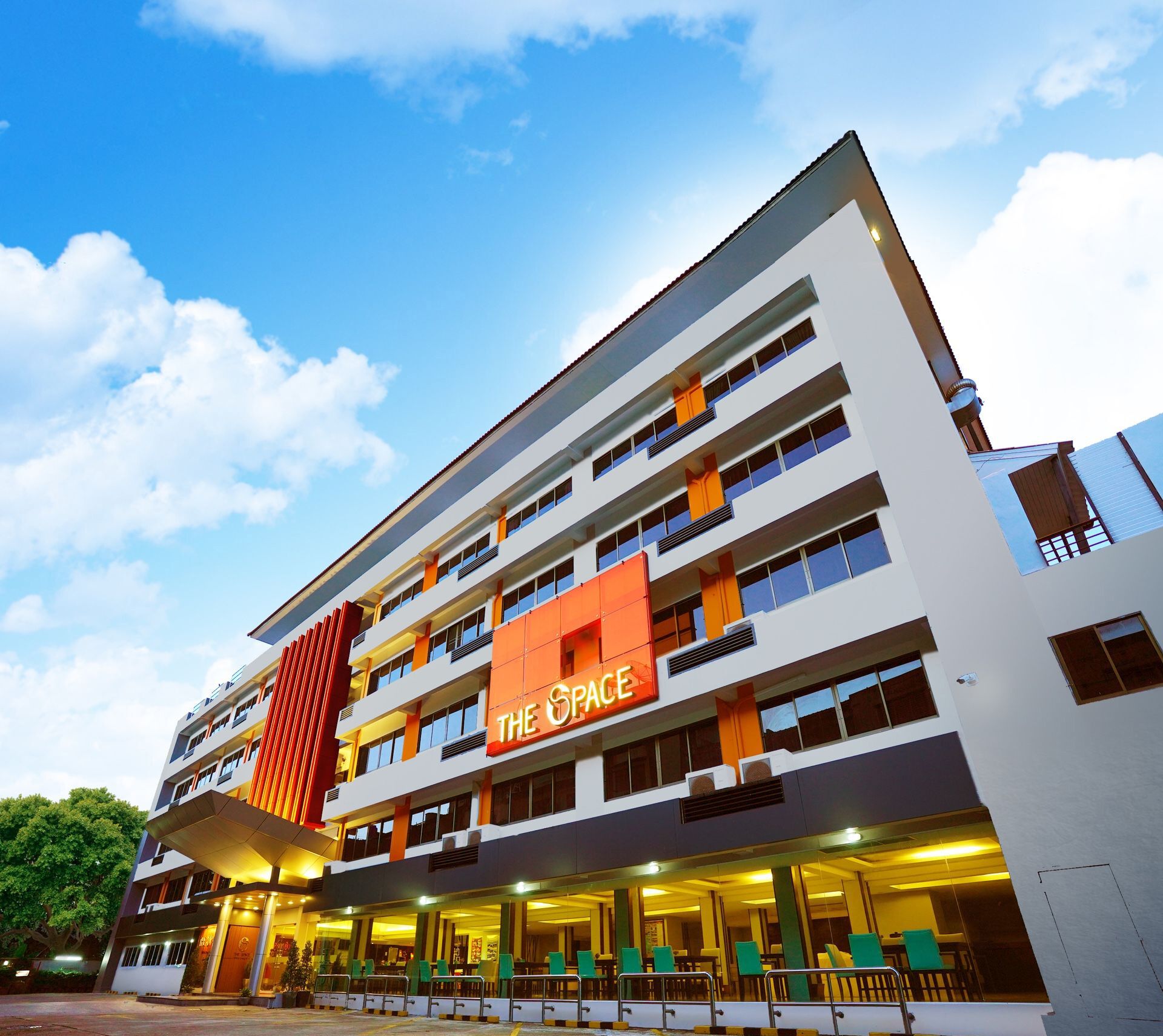 Een hotel met meerdere verdiepingen met een opvallend oranje bord waarop 