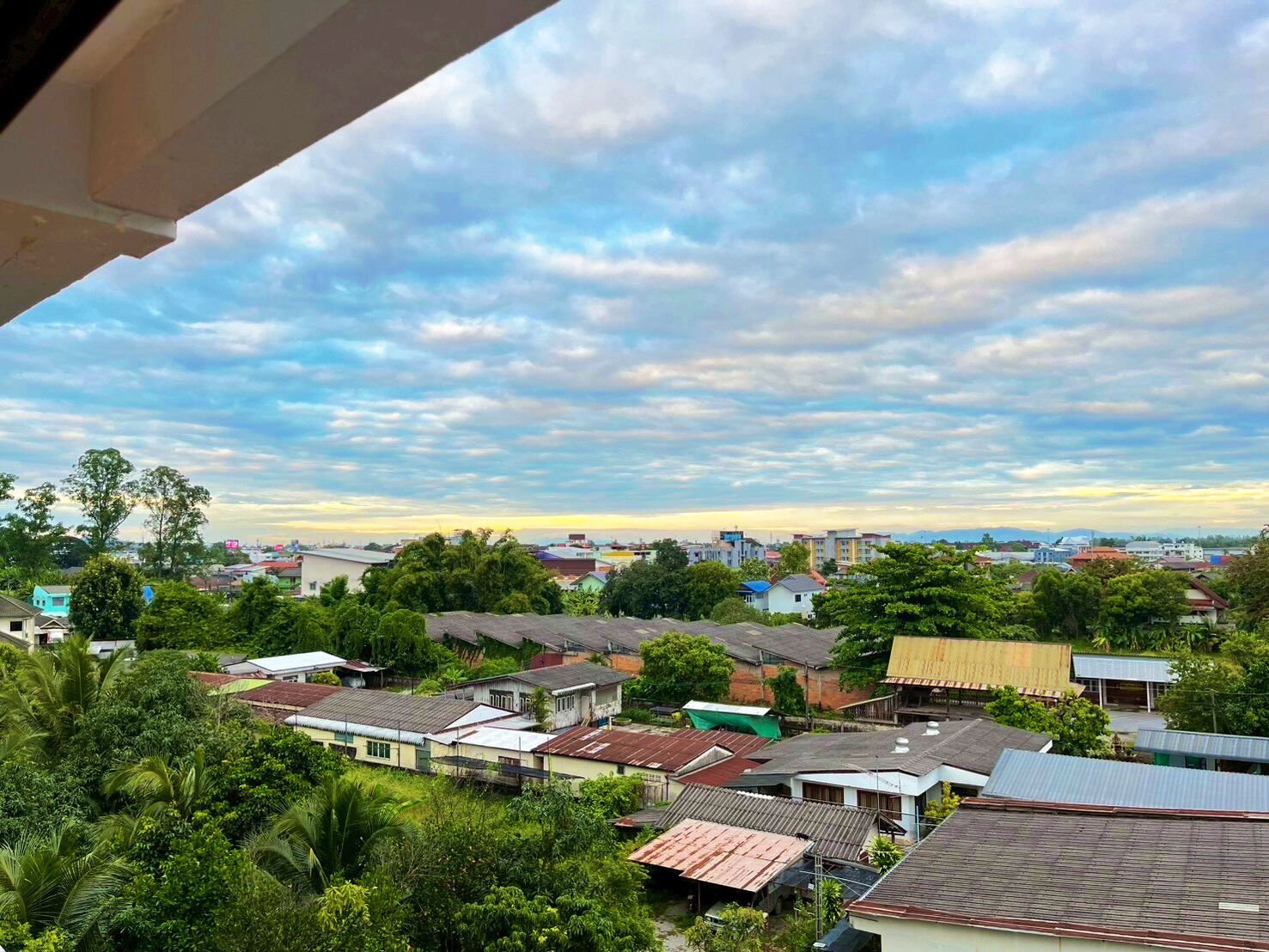 A residential area with houses, trees, and a clear sky.