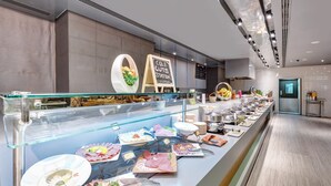 A buffet area with various food items displayed on a counter, a sign indicating 'Cold Cuts Station', and a glass display case. - The Act Hotel Sharjah (Sharjah)