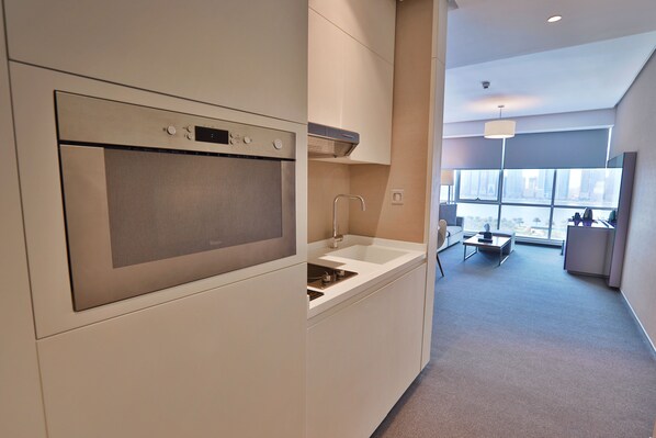 Una cocina moderna con electrodomésticos de acero inoxidable, un lavamanos integrado y ventana con vista a la ciudad.
