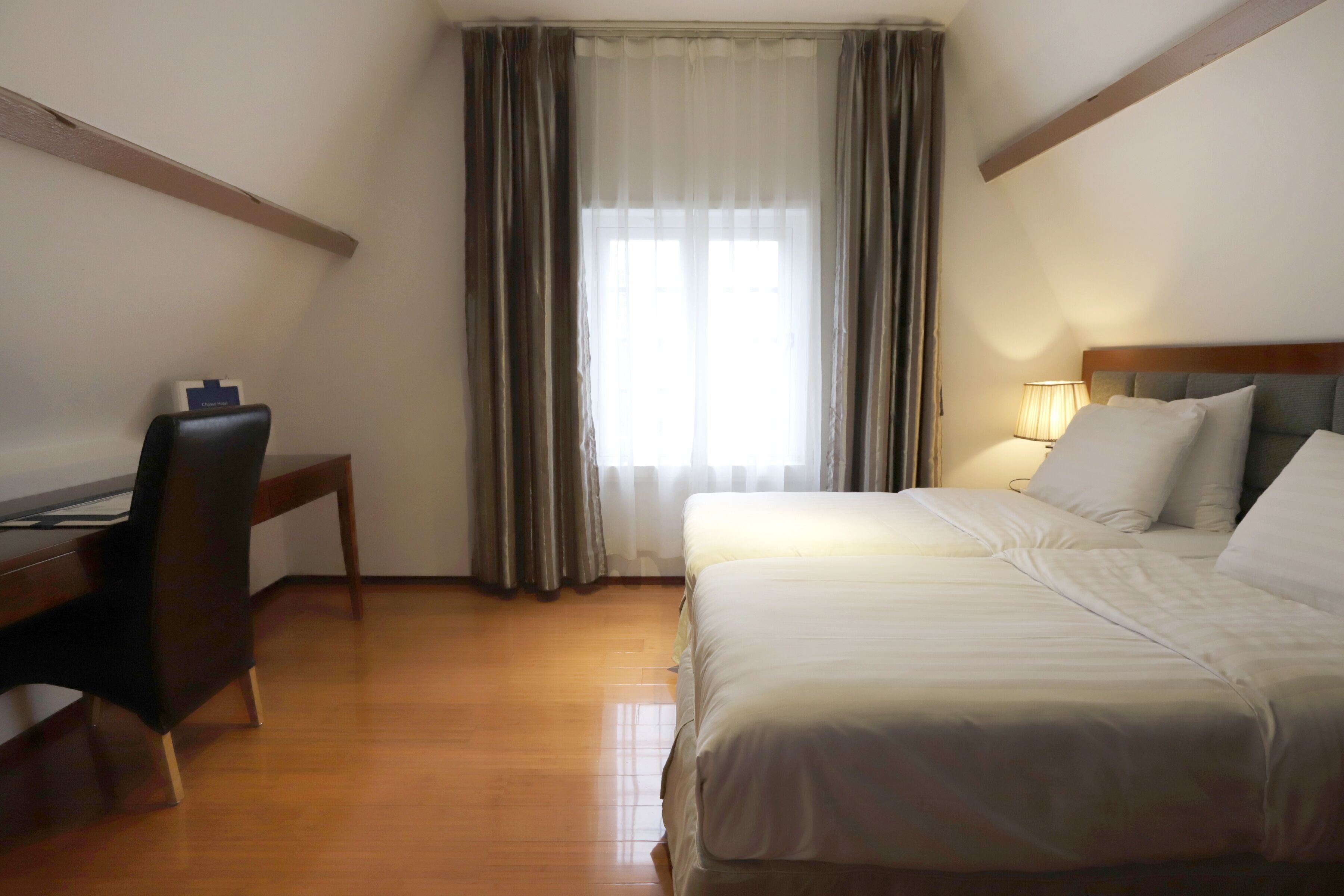 Een hotelkamer met een bed, een bureau en een stoel.
