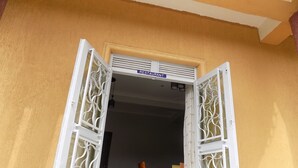 Una puerta abierta con un letrero que dice “RESTAURANT” arriba, que da acceso a un comedor con mesas y sillas.