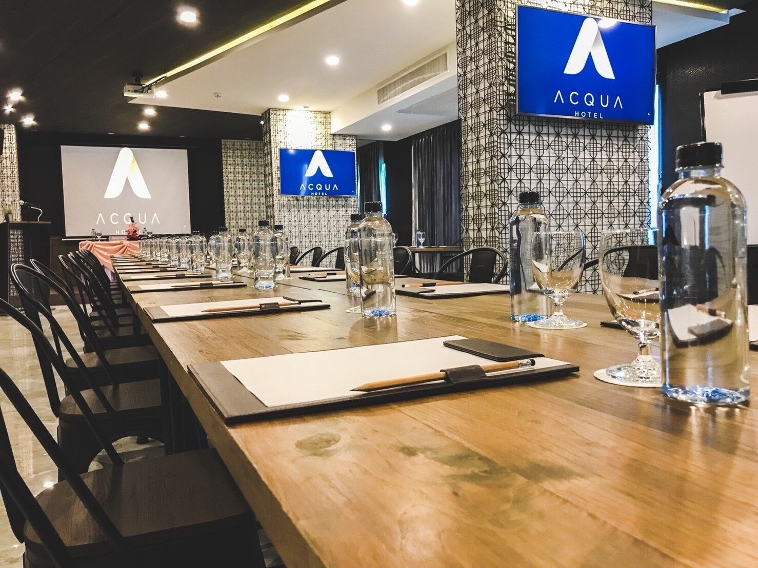 A conference room with a long table, chairs, water bottles, and glasses.