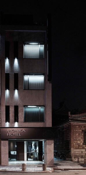 A modern hotel with multiple floors, large windows, and a sign reading "Monka Hotel". - Monka Hotel (Taipei)