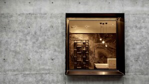 Un baño moderno y minimalista con cabina de ducha integrada y un inodoro a la vista.