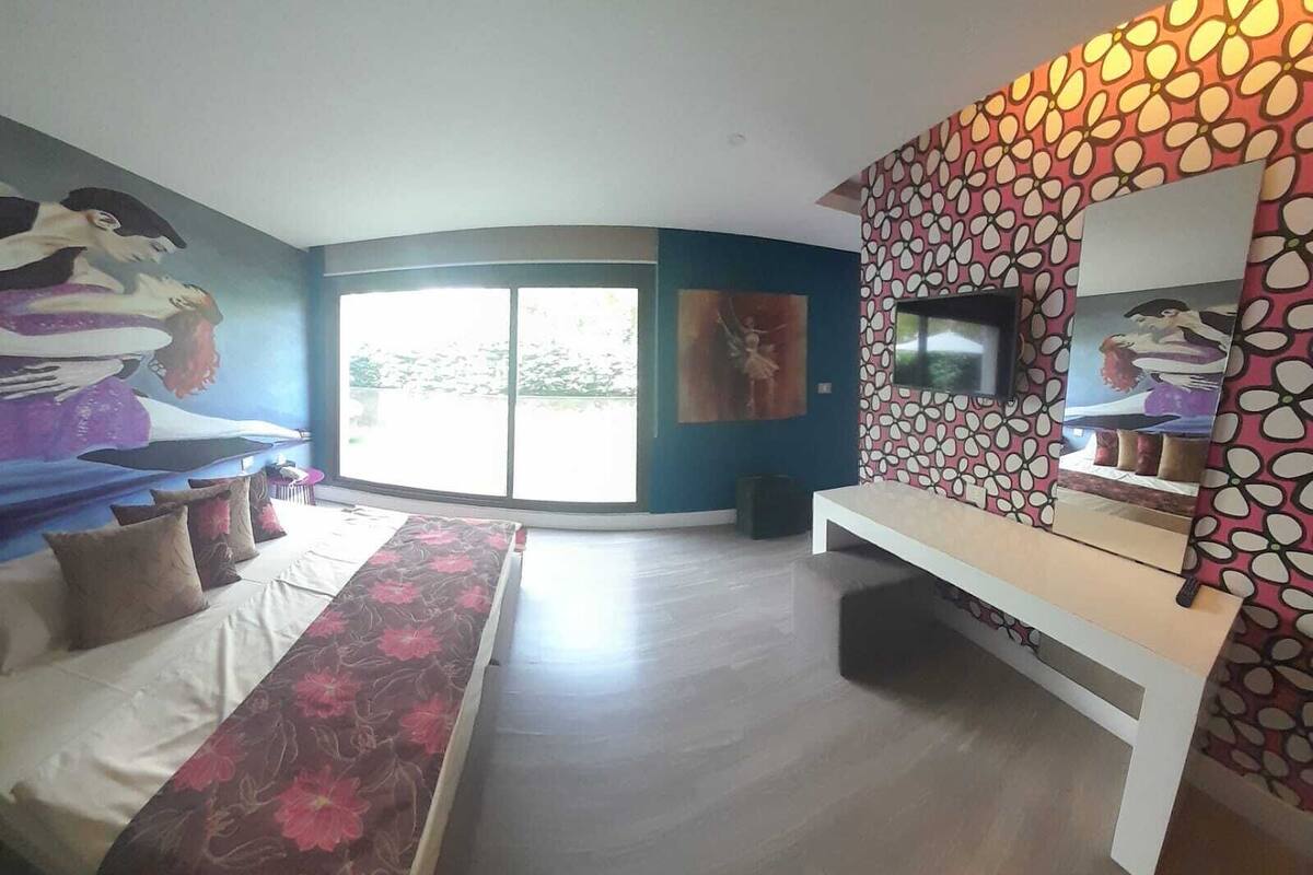 Un salon moderne avec un canapé, un long banc, un téléviseur et une grande fenêtre.