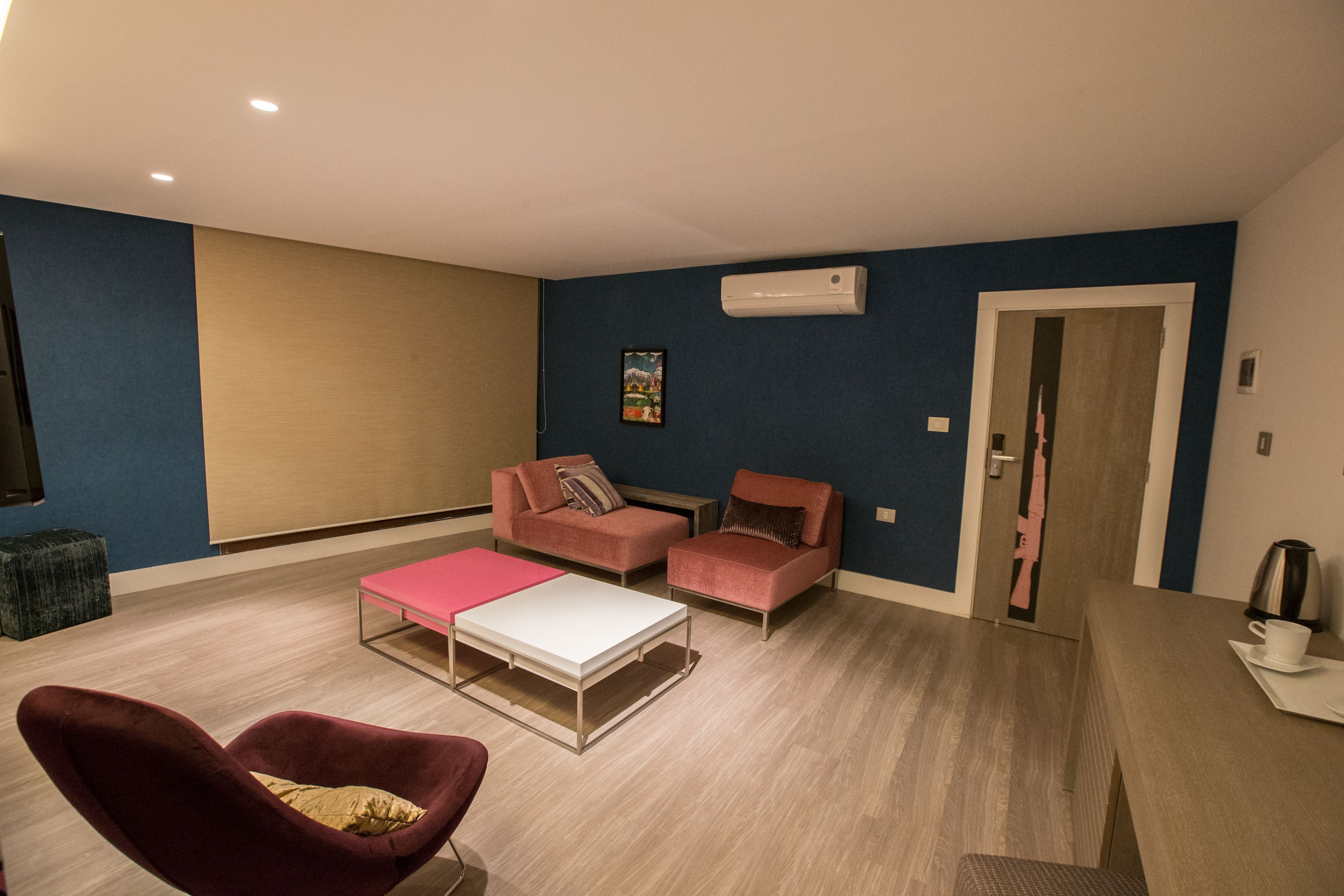 Una sala de estar moderna con dos sofás, una mesa de centro y un sillón rojo.
