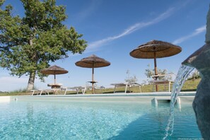 Una piscina al aire libre, tumbonas