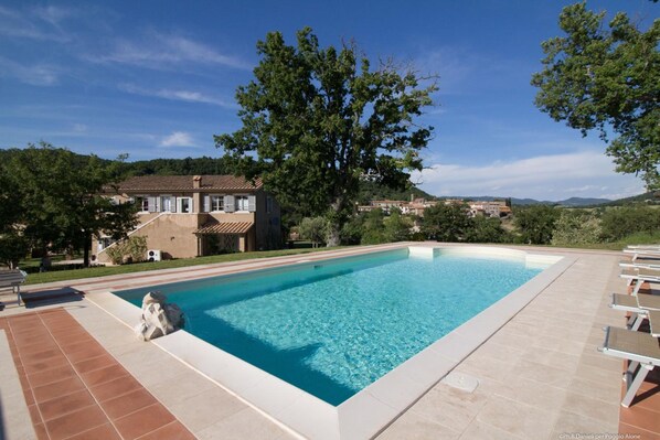 Alberca al aire libre y camastros 