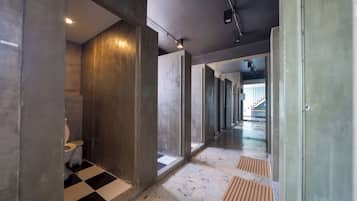 A hallway with a checkered floor, a toilet, and concrete walls.