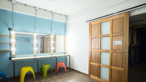 Una habitación con un espejo, taburetes y una puerta de madera con una placa.