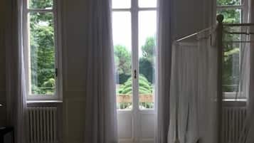 Una habitación con candelabro, ventanas amplias y suelo estampado.