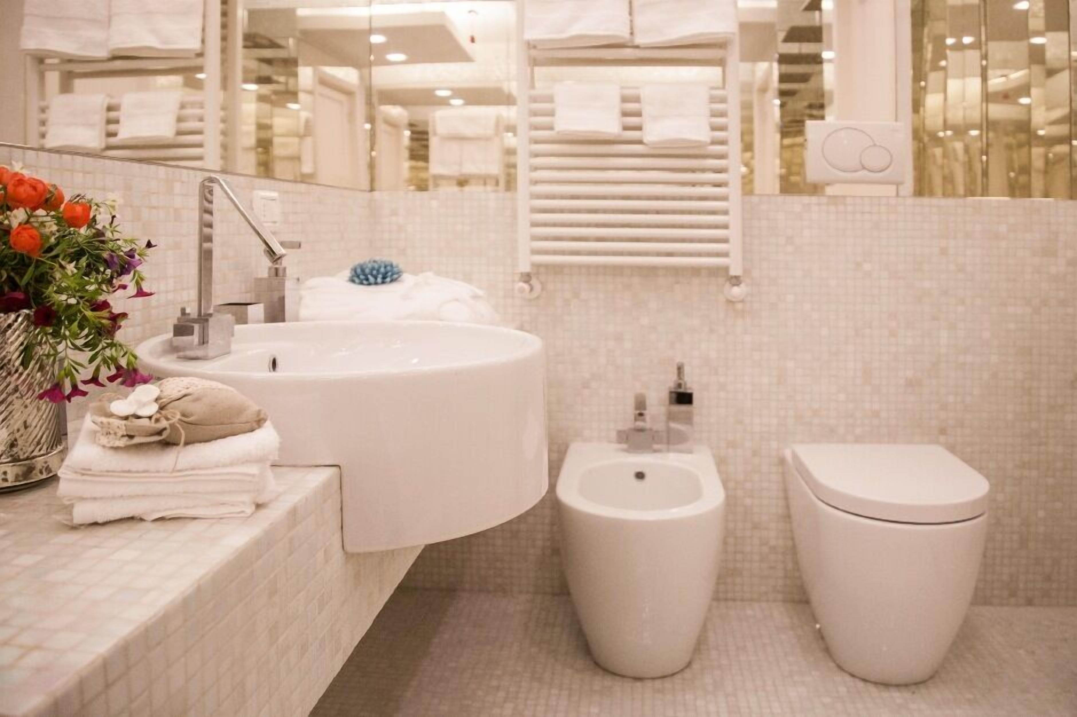 Un bagno moderno con lavandino ampio, bidet e water.