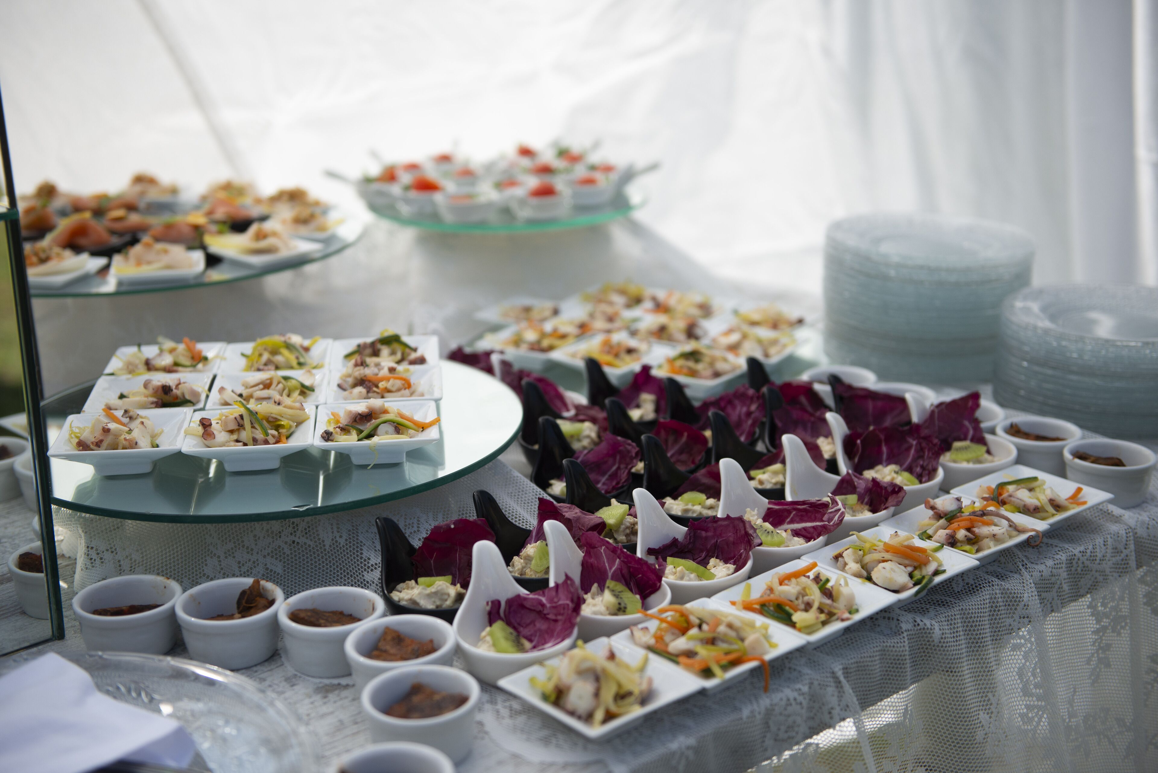 A buffet table with various dishes and small bowls of sauces.