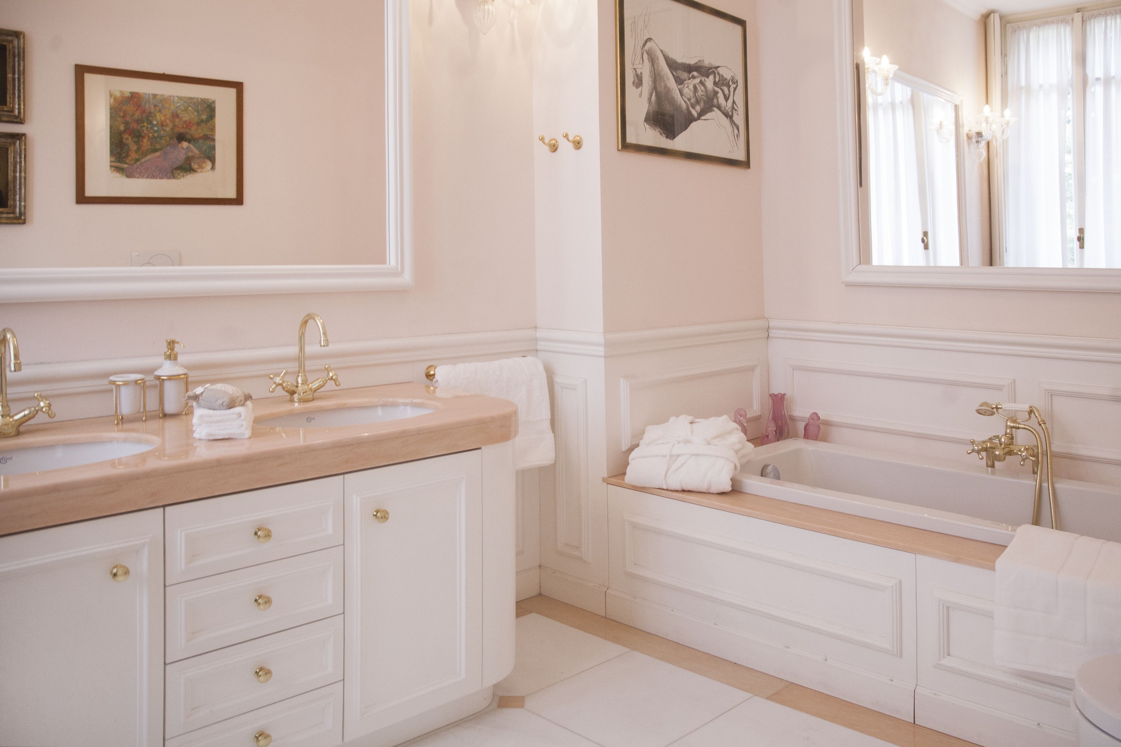 A bathroom with two sinks, a bathtub, and a large mirror.