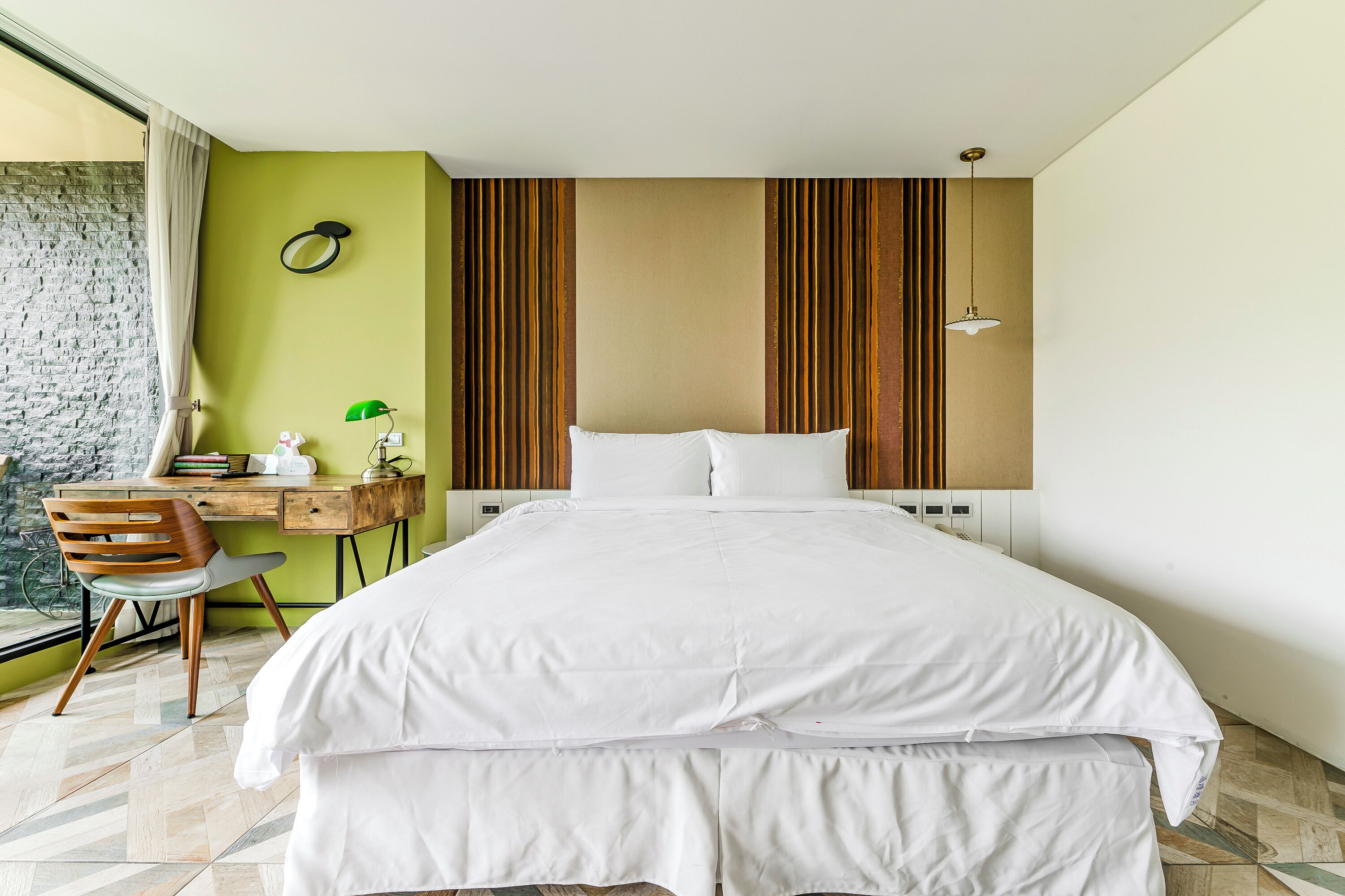 A neatly arranged bedroom with a bed, a desk, and a chair.