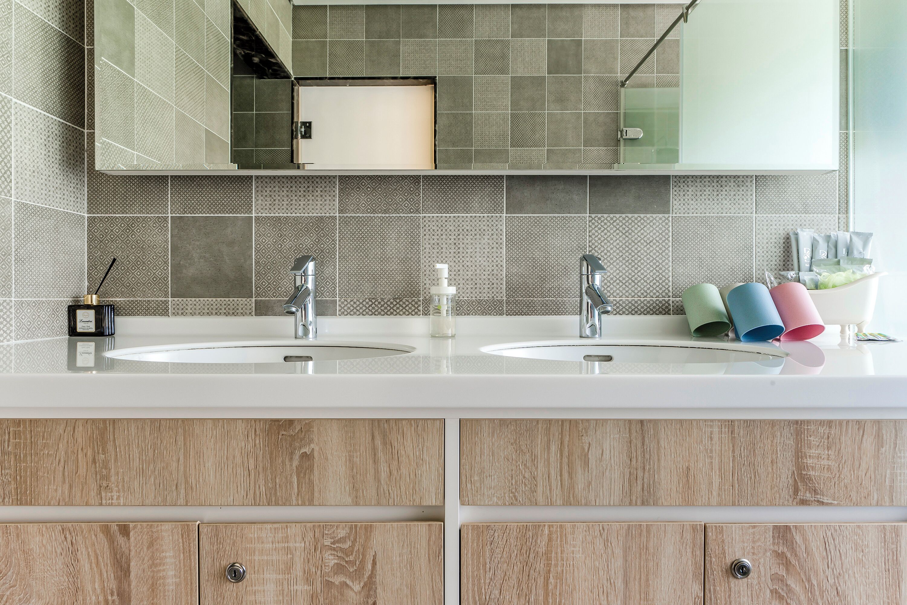 A bathroom with two sinks, a mirror, and a cabinet with drawers.