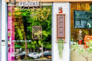A storefront with a 'WELCOME' sign, a 'Wi-Fi' sign, and a 'CLEANING' sign. - Han Yan Design Hotel (Yuchi)