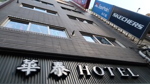 A hotel with a modern facade, featuring a prominent sign with the name 'Hotel' and a large 'SKECHERS' sign above it. - Hua Tai Hotel (Hsinchu)