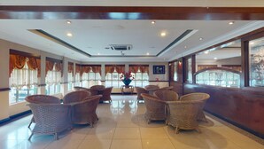A spacious lobby with wicker furniture, large windows with curtains, and a polished floor. - TS Hotel - Scientex (Pasir Gudang)