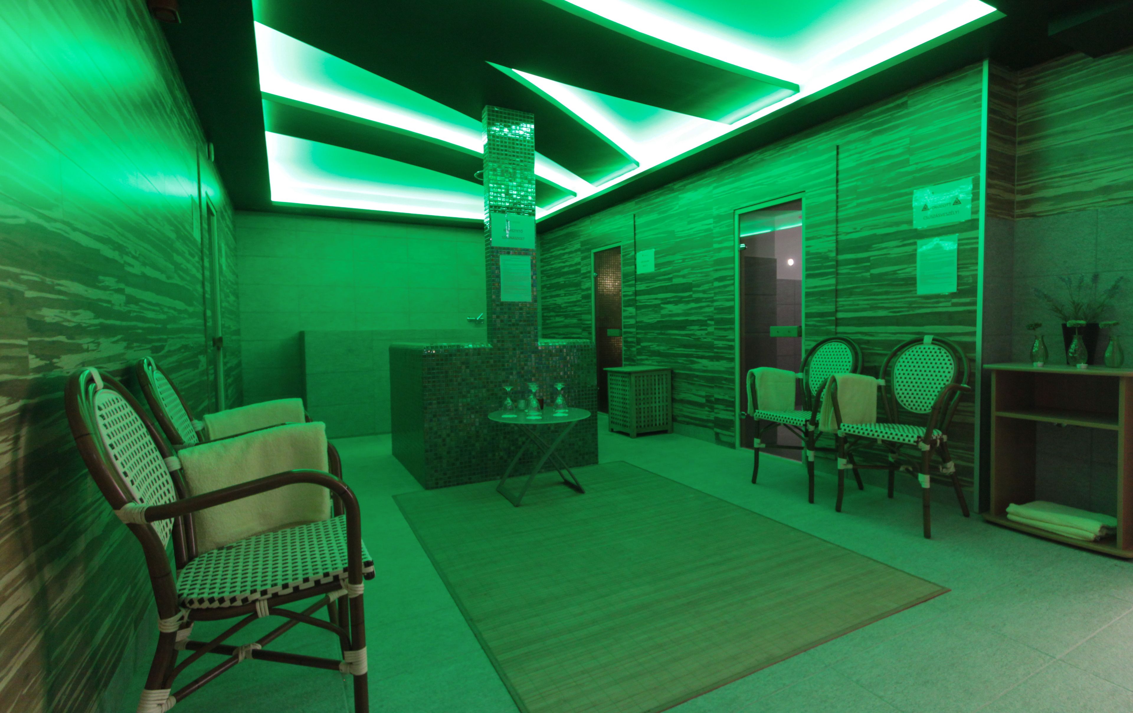 A spa area with a reception desk, seating, and a massage table.