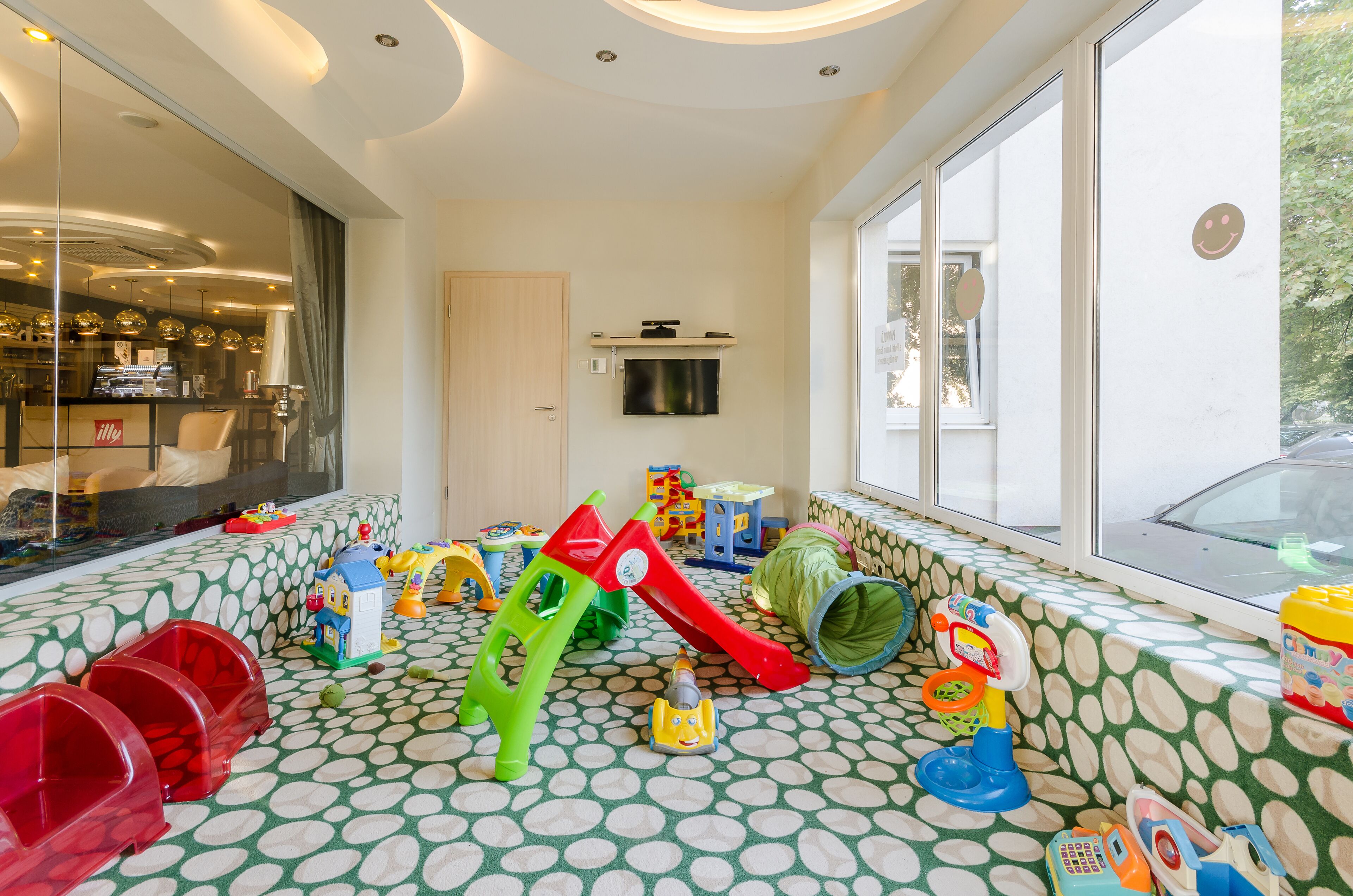Ein Spielbereich für Kinder mit verschiedenen Spielsachen und einer Rutsche.