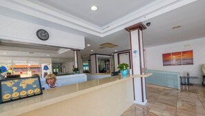 A hotel reception area with a reception desk, a world map display, a clock, and a Wi-Fi sign. - Golden Sand (Lloret de Mar)