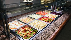 A buffet with various food options, a ship model, and a decorative garland. - Golden Sand (Lloret de Mar)