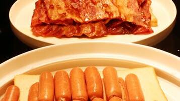 Three plates of food: sausages, a meat dish, and a meat dish with bread.