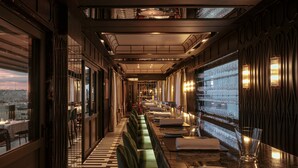 A restaurant with a long counter, multiple seating areas, and a view of the cityscape through large windows. - 1926 Le Soleil Hotel & SPA (Sliema)