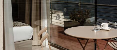 Un balcon avec une table ronde, une chaise et un canapé.