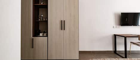 A modern bedroom with a wardrobe, a bed, a TV, and a small table.
