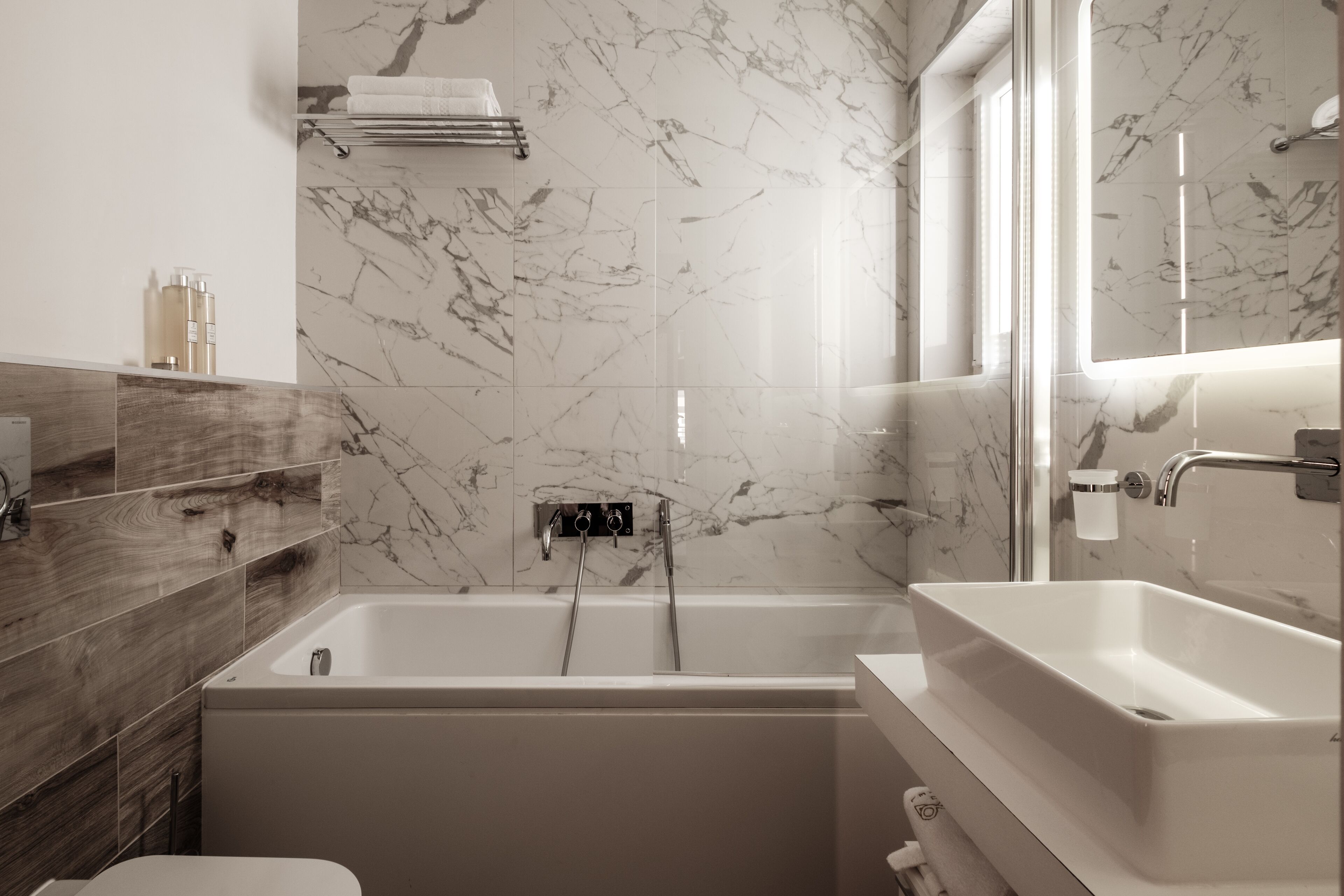 Un baño moderno con una bañera independiente, un lavamanos separado y un tocador.