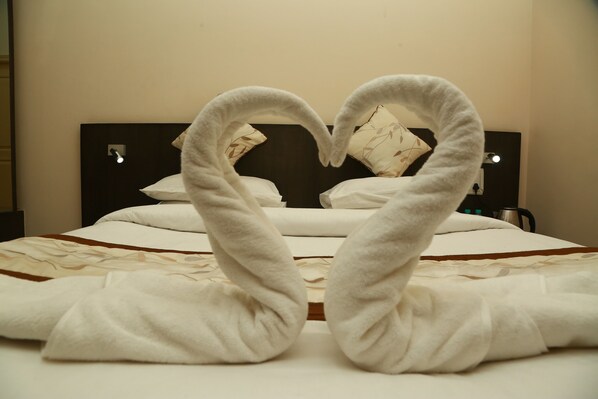 A bed with a heart-shaped towel arrangement.