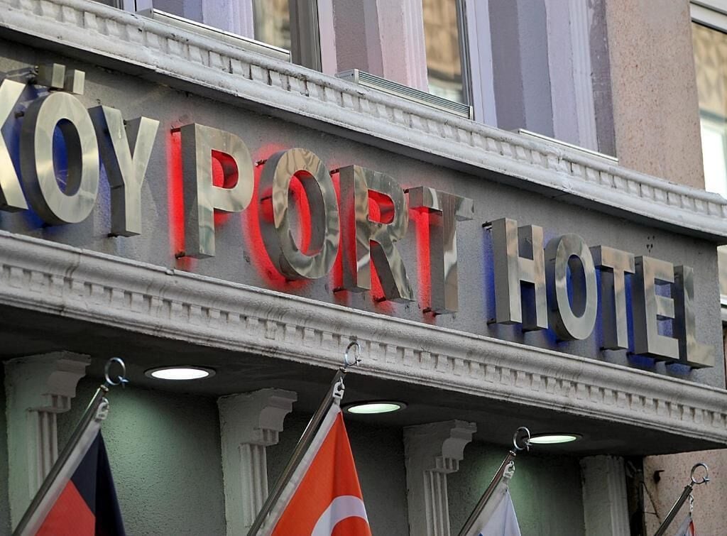 Segnaletica di un hotel con il nome 'KOYPORT HOTEL' in caratteri grandi e in grassetto.