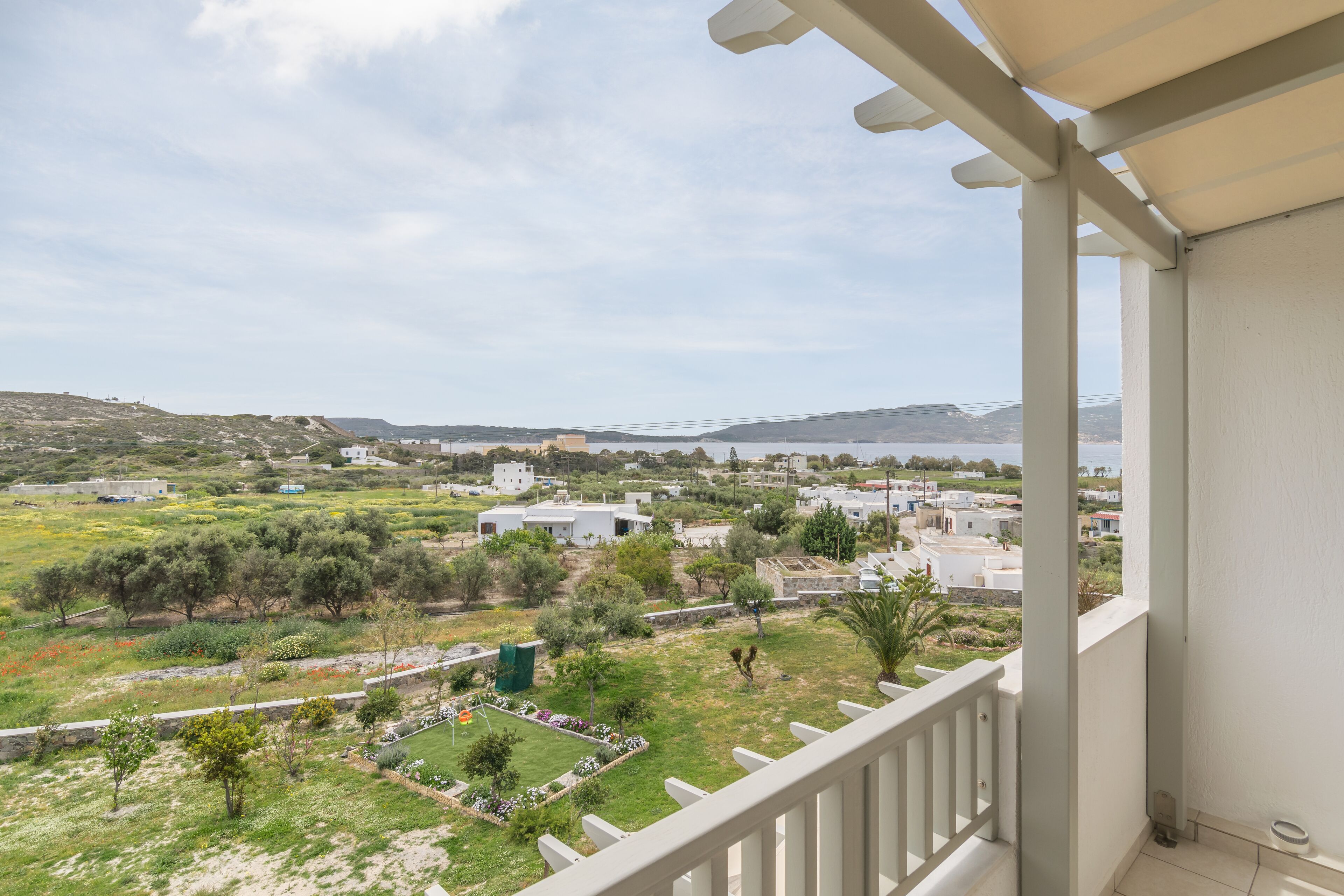 Un balcon donnant sur un quartier résidentiel, avec vue sur des maisons et des espaces verts.