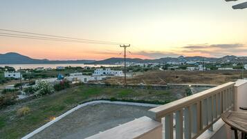 Un balcón con vista a un pueblo costero al atardecer.