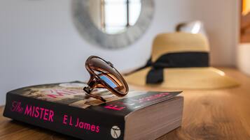 A book titled 'The Mister El James' on a wooden surface with a pair of glasses on top.