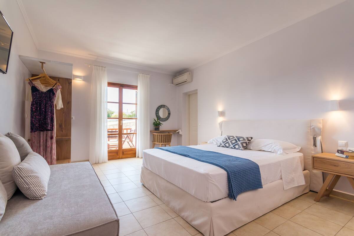 A bedroom with a bed, bedside table, and a chair.