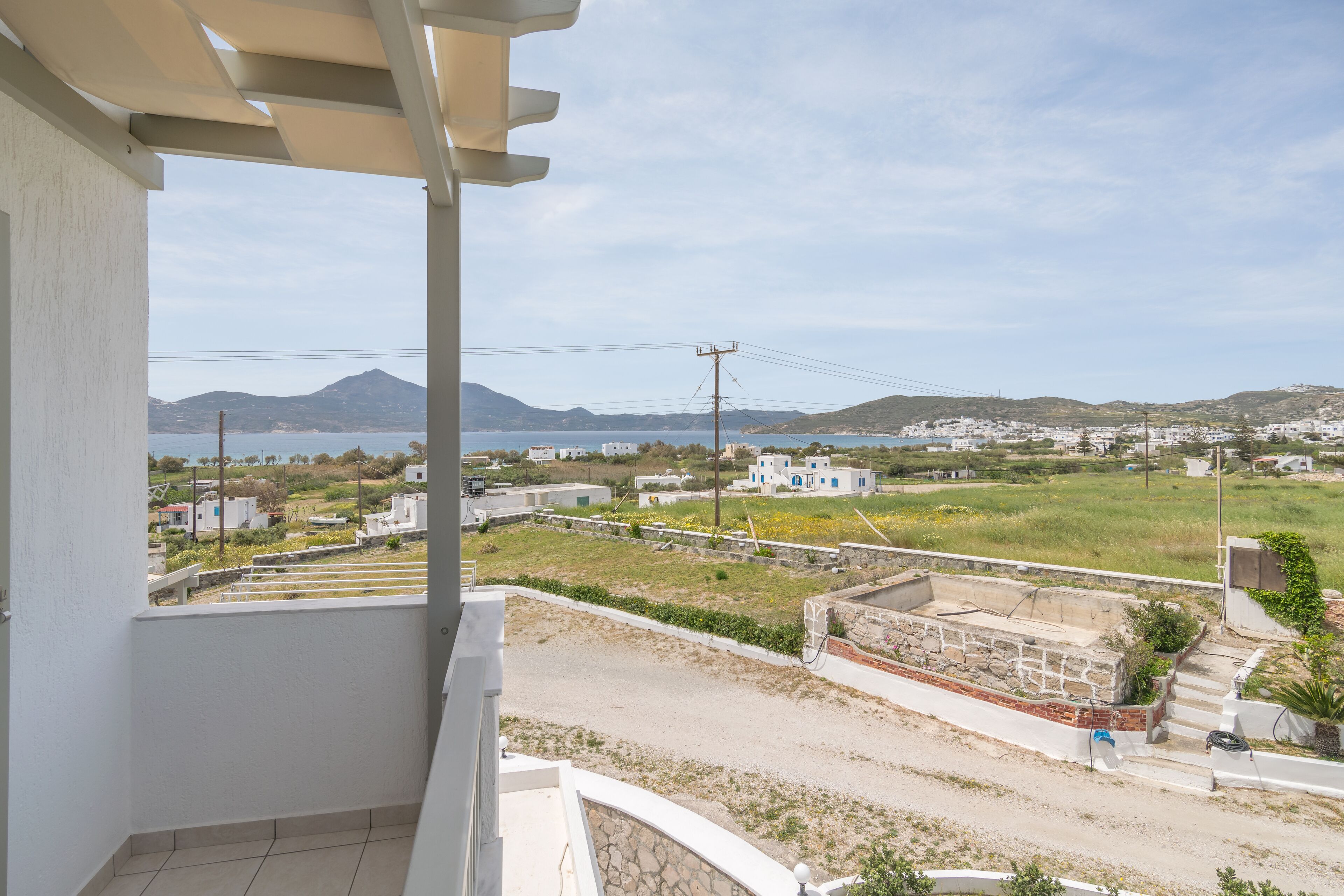 Een balkon met uitzicht op een kustplaatsje, inclusief huizen, een berg en een waterpartij.