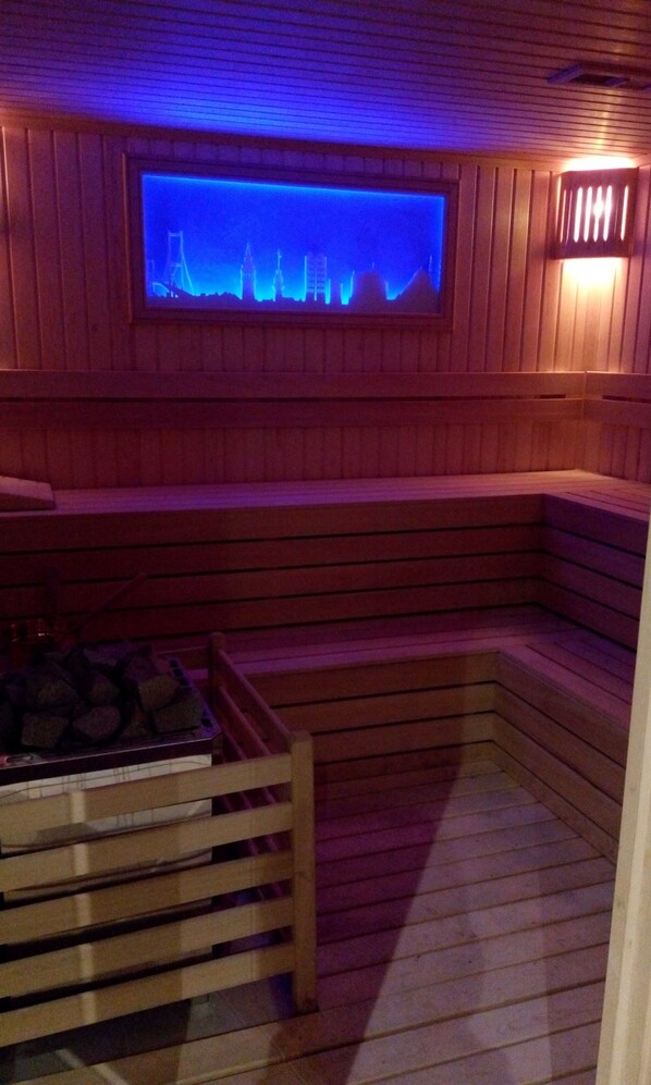 Una sauna con paredes de madera, un banco y un estante de piedra.