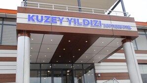 A entrada do Hotel Boutique KUZEY YILDIZI, com design moderno, destacando uma placa e fachada de vidro.