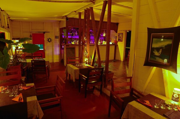 Un restaurante acogedor con mobiliario de madera y una zona de bar.