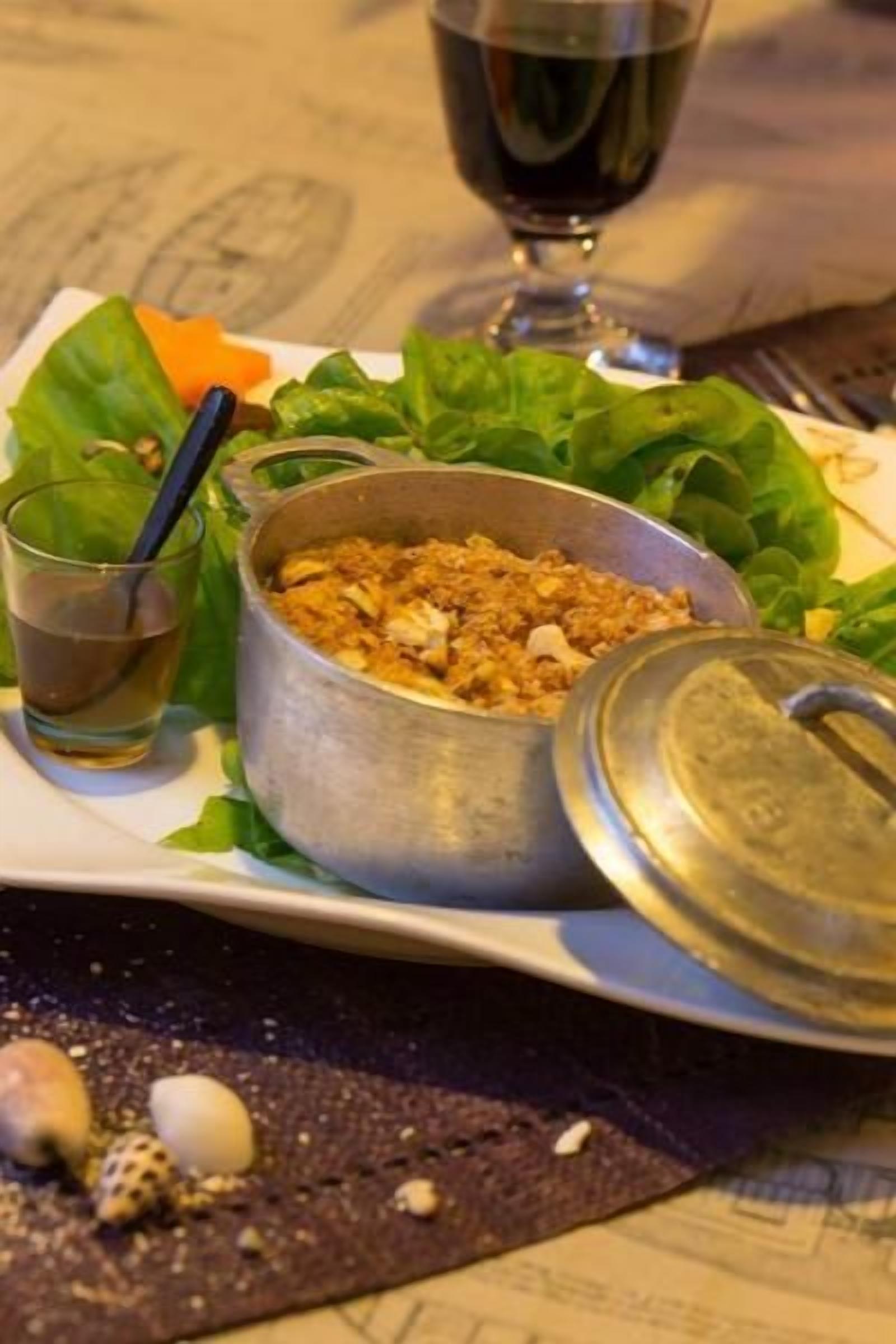 Un pasto con una ciotola di cibo, un bicchiere di bevanda e un piatto di verdure.