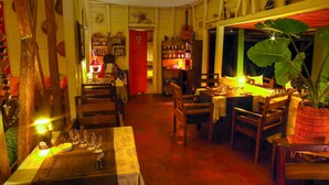 Un restaurante acogedor con mobiliario de madera, mesas dispuestas con platos y vasos, y un ambiente cálido.