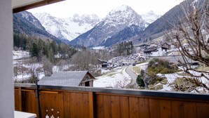 A view from a balcony overlooking a snowy mountain landscape with a village below. - Kella-Egg (Brand)