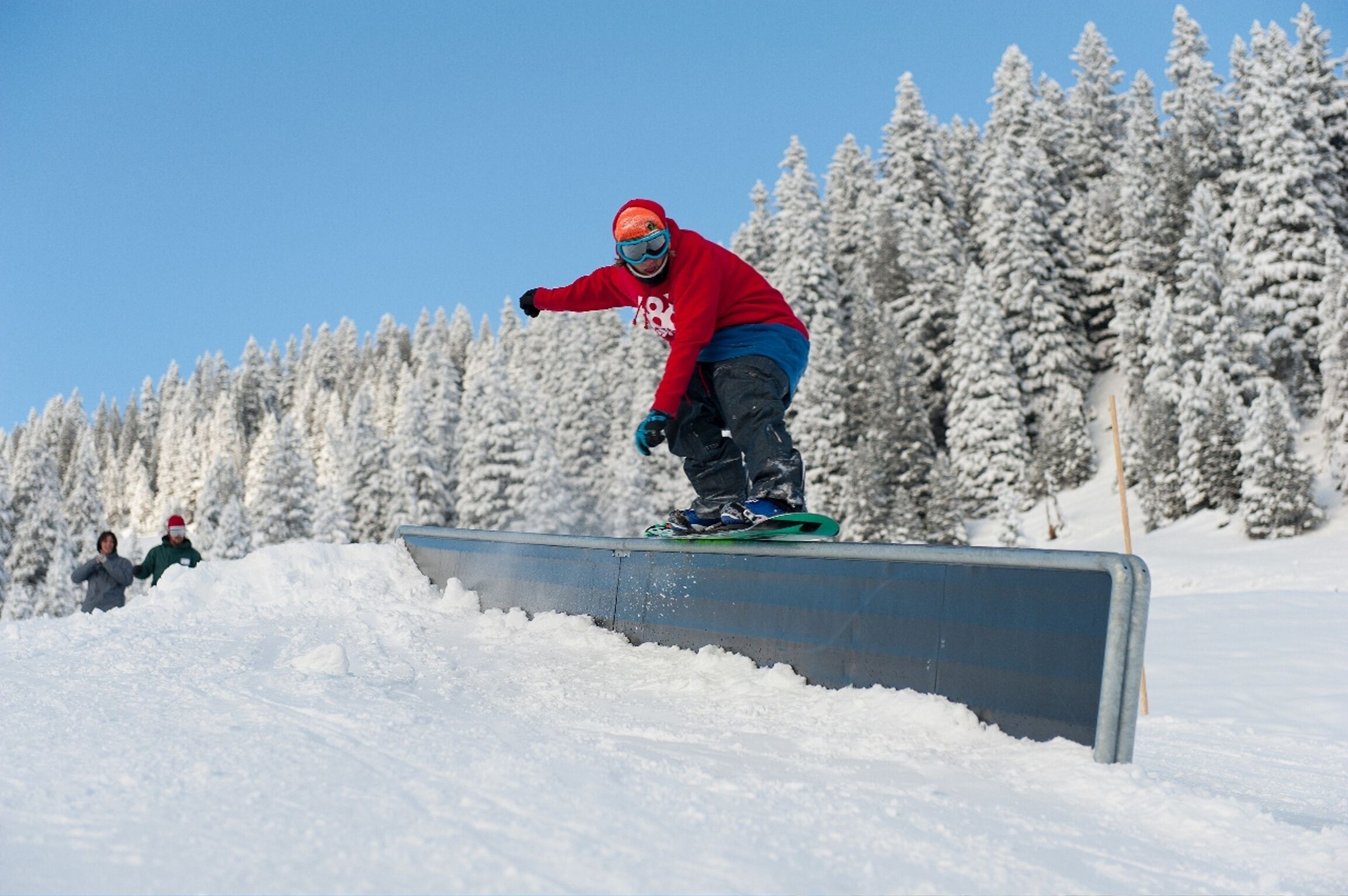 A snowboarder performing a trick on a rail.