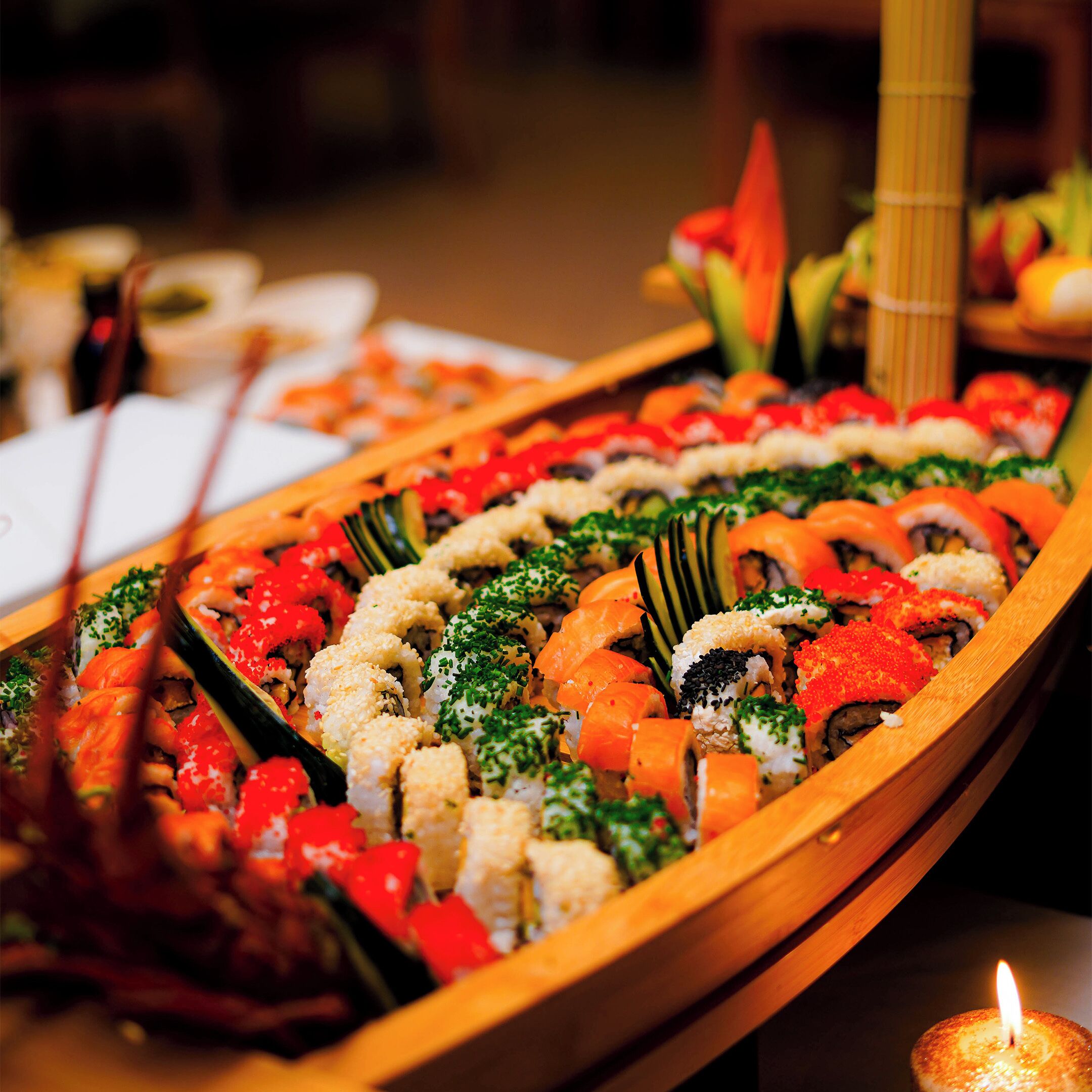 Un bote de madera lleno de diferentes platos de sushi.